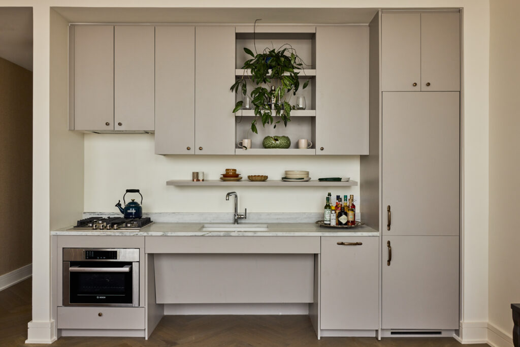 Suite kitchenette with open shelving, plants and full-size appliances at The Nickel Hotel