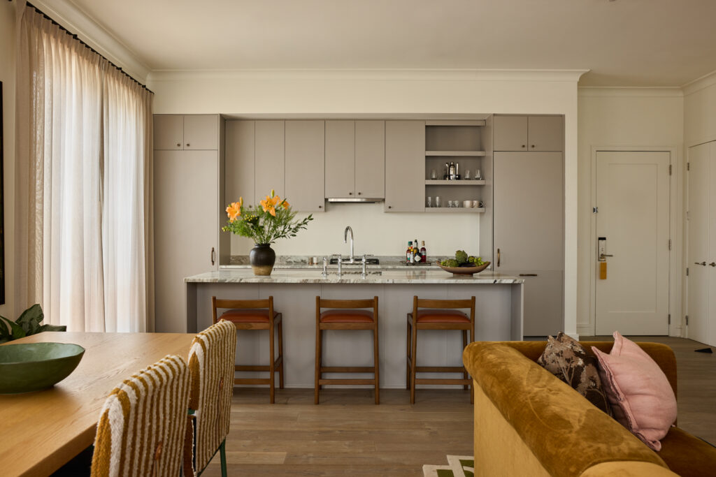Full kitchen with marble counters and counter stools in a Charleston boutique hotel suite