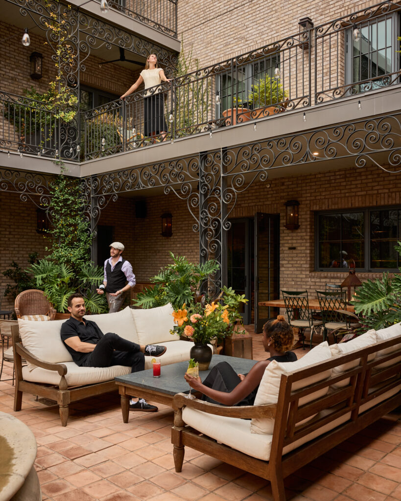 Guests lounging in the brick courtyard of The Nickel Hotel on King Street, Charleston