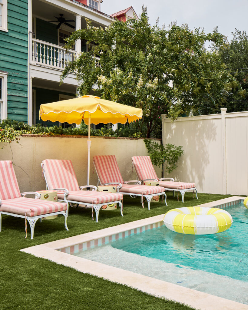 Pink striped loungers and yellow umbrella beside the saltwater pool at Spring Sanctuary